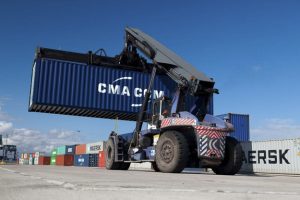 Dramatic industrial photograph of a container forklift in PD Ports container terminal transporting a container to be stored.