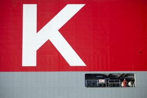 Professional industrial and transport shot which is a close up of the K-Line ship showing the letter K in white surrounded by red. Just below is a worker on the ship which just shows the vastness of the ship. Shot by professional north-east photographer Cal Carey.