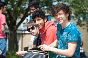 Professional advertising shot showing three boys sat down, looking on. Shot for the college prospectus. Shot by professional adverting photographer Cal Carey.