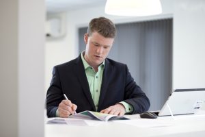 This is a corporate shot of a suited Greenbank employee working in an office setting in Middlesbrough, Teeside.