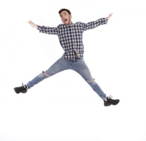 A professional shot of a student jumping for joy and success in a beautifully light shot for an advertising and recruitment campaign for Redcar and Cleveland College.