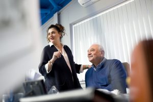 Professional advertising shot showing two workers talking, one worker in a chair, the other worker standing. Shot by professional northeast commercial photographer Cal Carey.