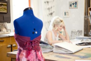 Professional advertising shot showing a young girl at a desk with a mannequin out of focus in the foreground. Shot by professional northeast advertising photographer Cal Carey.