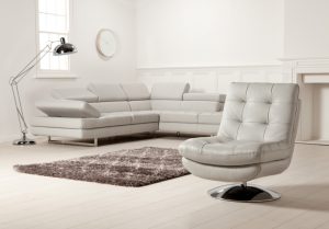 A grey Barker & Stonehouse armchair, lamp and sofa in a light room set.