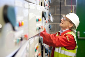 Professional industrial shot of a worker carrying out electrical work on a control panel at a biodiesel refinery. Shot by professional northeast industrial photographer Cal Carey.