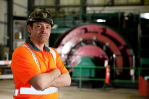 Professional advertising photography shot showing a man in a high-visabilty shirt and hard hat with an industrial background. Shot by professional northeast advertising photographer Cal Carey.