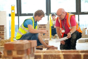 Professional advertising photography shot showing a student and a tutor with the student bricklaying. Shot by professional northeast advertising photographer Cal Carey.