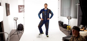 Behind the scenes shot showing the setup of an advertising photography shoot with the subject on a white background.