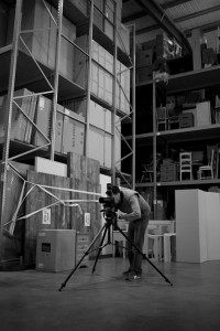 Black and white behind the scenes photography shot showing Cal Carey Photographer looking through his DSLR shooting the subject.