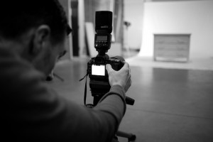 Black and white behind the scenes photography shot showing Cal Carey Photographer looking through his DSLR shooting the subject.