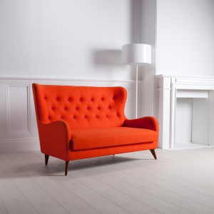 Professional product shot showing an orange sofa sat in a white room. Shot by professional northeast product photographer Cal Carey.