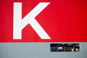 Professional industrial and transport shot which is a close up of the K-Line ship showing the letter K in white surrounded by red. Just below is a worker on the ship which just shows the vastness of the ship. Shot by professional north-east photographer Cal Carey.
