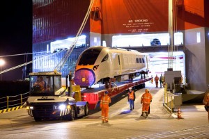 Professional industrial and transport shot of a Hitachi train being loaded out of the ship, with workers in high-visabilty clothing. Exterior of the ship. Shot by professional north-east photographer Cal Carey.