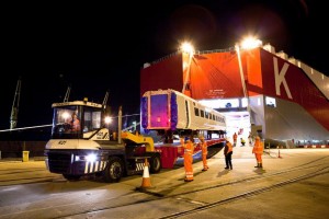 Professional industrial and transport shot of a Hitachi train being loaded out of the ship, with workers in high-visabilty clothing. Exterior of the ship. Shot by professional north-east photographer Cal Carey.