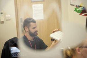 Professional commercial photography shot of a odyssey team member examining a piece of equipment. Shot by professional northeast commercial photographer Cal Carey.
