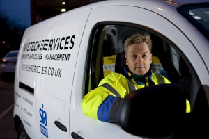Professional commercial shot showing a Vistech security guard in a high-visibility coat looking out the window of a Vistech Services van. Shot by professional northeast commercial photographer Cal Carey.