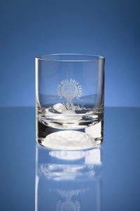 Professional product photography shot showing a drinks glass with the effect of half a golf ball at the bottom. Shot on a blue background. Shot by professional northeast product photographer Cal Carey.