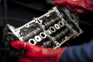 Professional industrial photography shot showing a motor part being handled with hands in the frame covered with red gloves. Shot by professional northeast industrial photographer Cal Carey.
