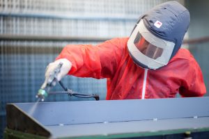 This is a professional industrial shot of a Tees Components Ltd worker refurbishing a piece of equipments in a specialist suit. Shot by professional northeast commercial industrial photographer Cal Carey.