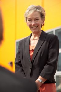 Professional commercial photography shot showing a portrait shot of a woman with the yellow of the building out of focus in the background. Shot by professional northeast commercial photographer Cal Carey.