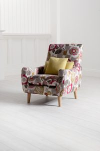 A patterned Barker & Stonehouse armchair, lamp and sofa in a light room set.